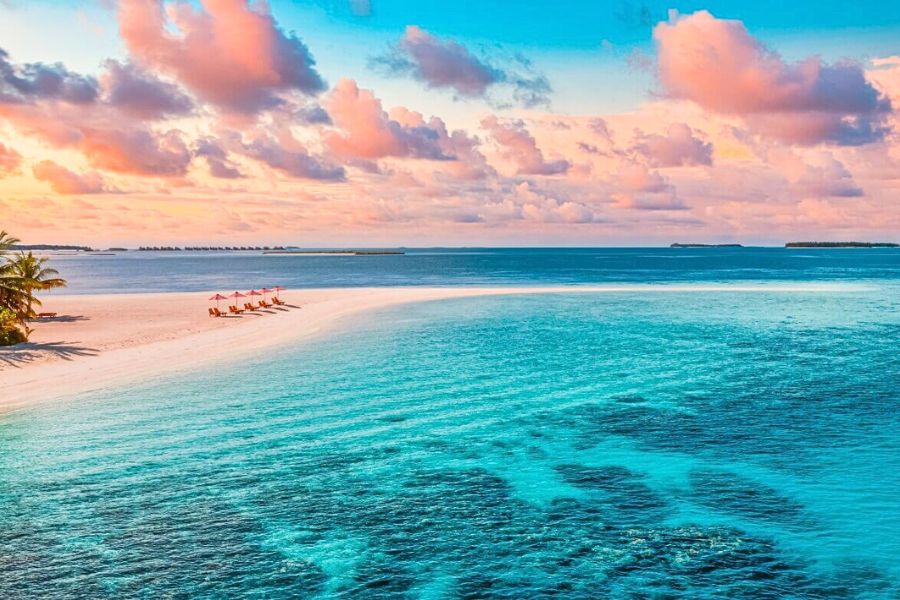 Calm Maldives lagoon beneath changing tropical clouds