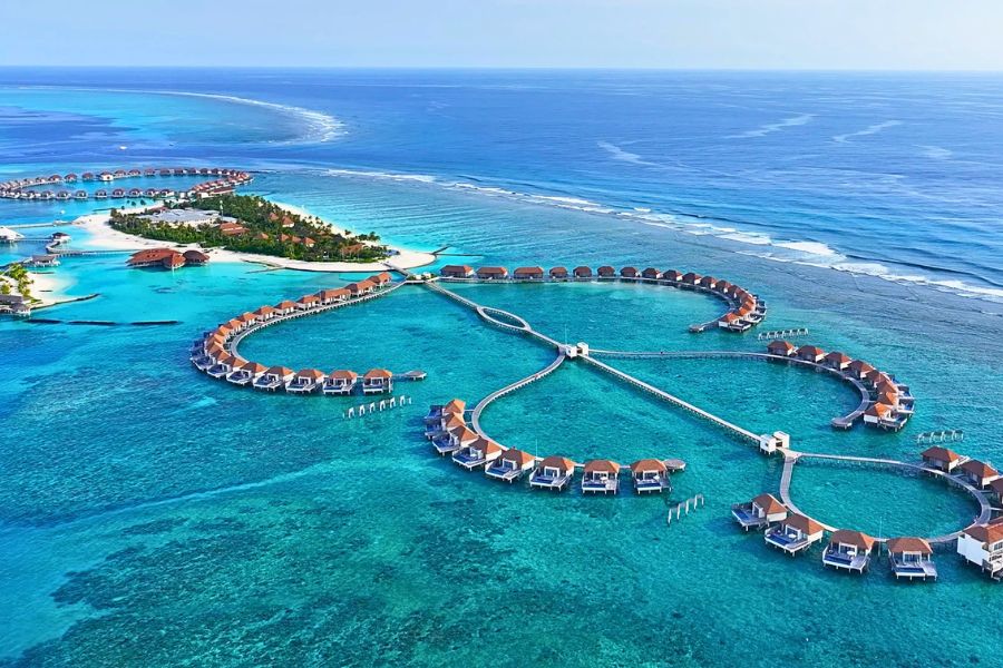 Overwater villas extending across a Maldives resort lagoon