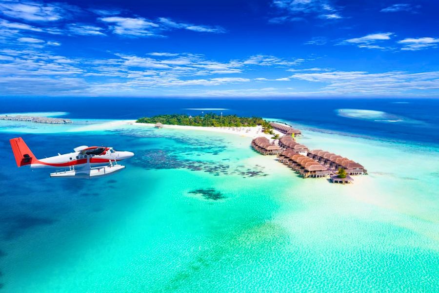 Seaplane flying over a tropical island in the Maldives