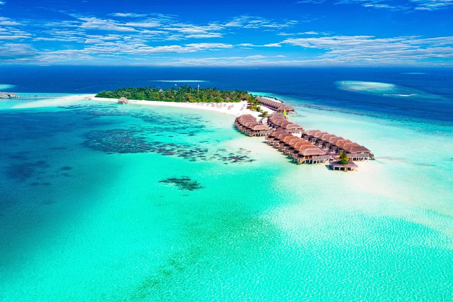 Small tropical island surrounded by turquoise water in the Maldives